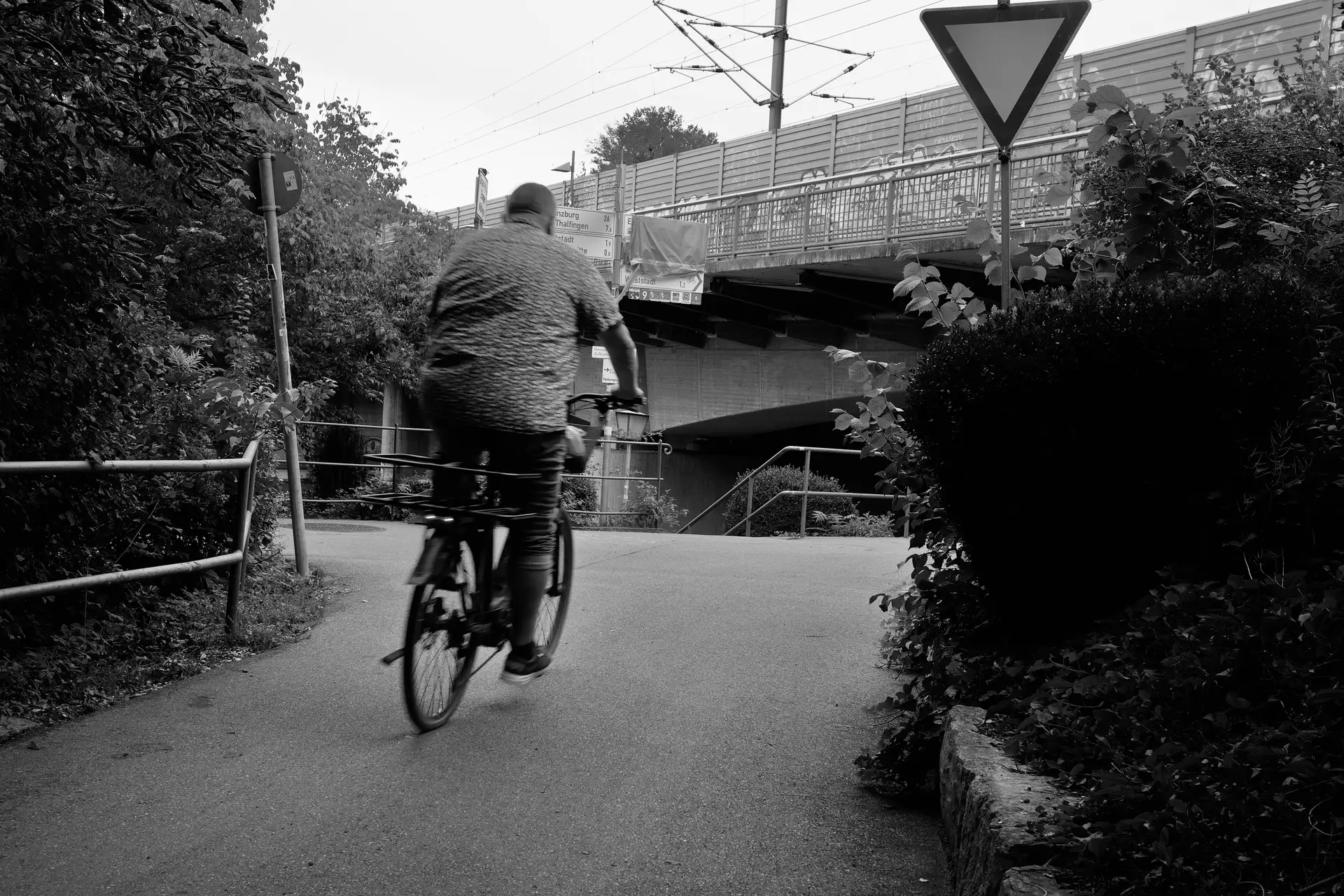 A cyclist with motion blur starting to take a 90 degree curve.